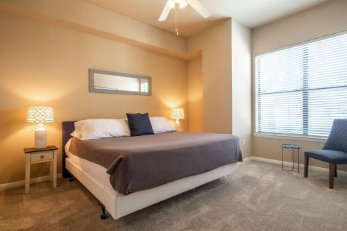 a bedroom with a bed and a blue chair at 2BR Executive Suite With Pool, Gym and Fast Wi-Fi By ENVITAE in Dallas