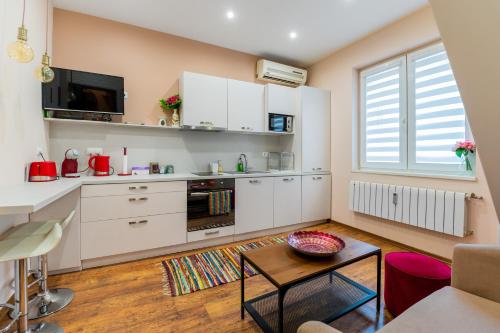 a kitchen with white cabinets and a table in a room at ~ Colorful Dream Apartment ~ 2BD in the TOP Center of Sofia in Sofia