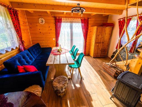 a living room with a blue couch and a table at Domki pod Bieniatka w Szczyrku in Szczyrk