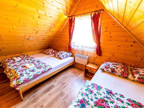 a bedroom with two beds in a wooden cabin at Domki pod Bieniatka w Szczyrku in Szczyrk