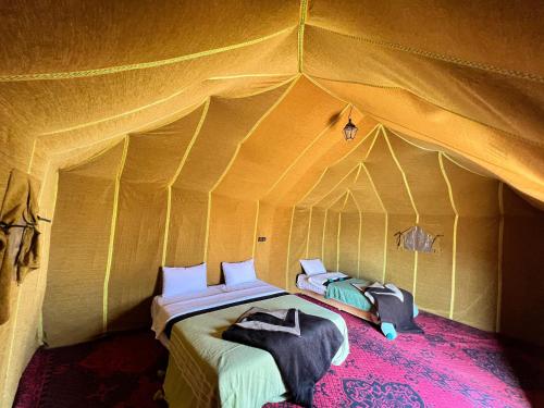 a bedroom with a bed in a tent at Merzouga Camp & Desert Activities in Merzouga