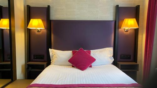 a bedroom with a large bed with a red pillow at Hotel Bellevue in Amboise