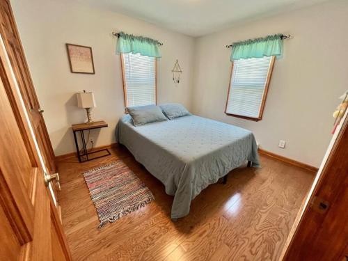 LansingにあるTHE GREEN HOUSE - New River Gorge National Parkのベッドルーム1室(ベッド1台、窓2つ付)