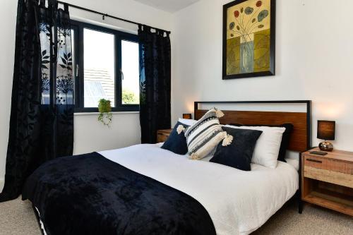 a bedroom with a large bed with black and white pillows at Just Stay Wales - Heatherslade House, Southgate in Parkmill
