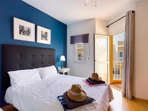カレタ・デ・フステにあるModern 3 bedroom house with large pool and fast internet, 100ft from the sea - sleeps 6のベッドルーム1室(ベッド1台、帽子2つ付)