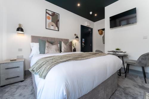 a bedroom with a large white bed and a chair at The Madison - Premium Self Check-In Studios & Apartments in Southampton