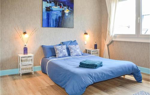 a bedroom with a blue bed with blue sheets and pillows at 5 Bedroom Cozy Home In Lézardrieux in Lézardrieux
