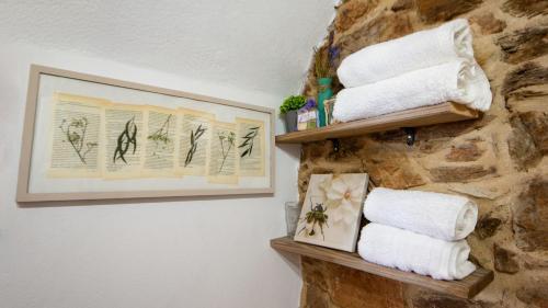 a bathroom with towels hanging on a stone wall at Apartamento duplex rural con chimenea y vistas panorámicas desde la cama in San Martín Sacalm