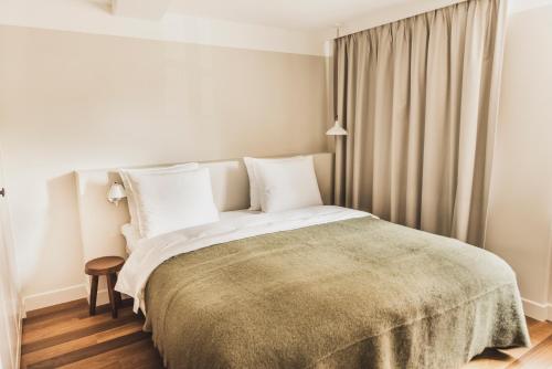 a bedroom with a large bed with a green blanket at Boutique Hotel Weesp in Weesp