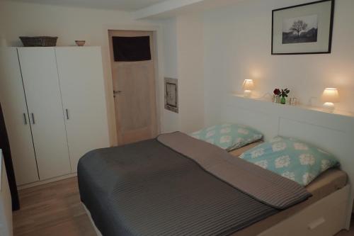 a bedroom with a bed and a white cabinet at Ferienwohnung Holzmaden Am Platz in Holzmaden