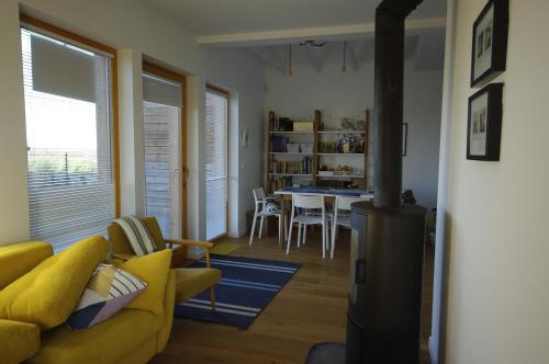 ein Wohnzimmer mit einem gelben Sofa und einem Tisch in der Unterkunft Błękitny domek in Darłowo