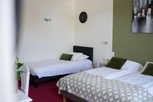 a hotel room with two beds with white sheets at Hôtel Picardia in Saint-Valery-sur-Somme