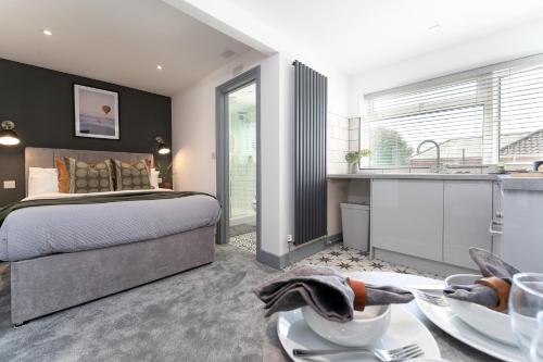 a bedroom with a bed and a kitchen with a sink at The Madison - Premium Self Check-In Studios & Apartments in Southampton