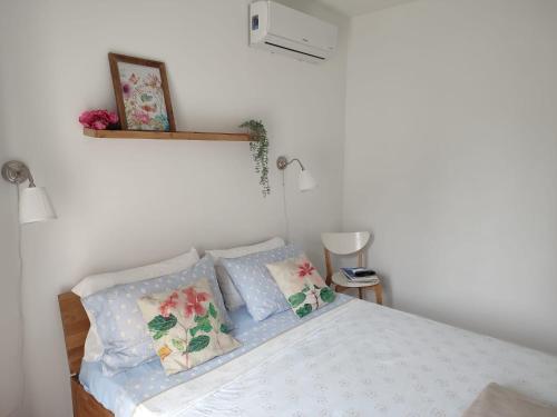 Schlafzimmer mit einem Bett mit blauen und rosa Kissen in der Unterkunft B&B Peonia in Porlezza