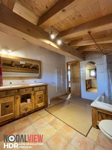 La salle de bains spacieuse est pourvue d'armoires en bois et d'un lavabo. dans l'établissement Chalet Du Pont D Arbon, à Megève
