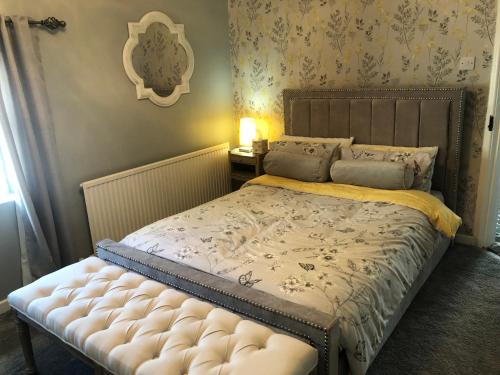 um quarto com uma cama com um colchão tufado em Old Smithy Cottage em Great Singleton