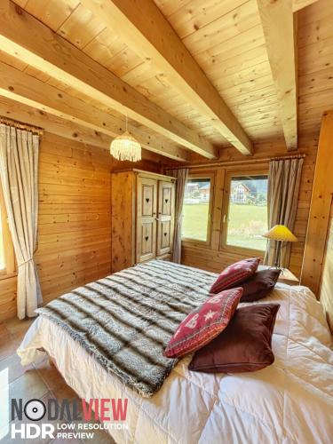 une chambre avec un lit avec des oreillers dessus dans l'établissement Chalet Du Pont D Arbon, à Megève