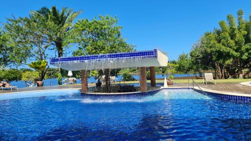 a swimming pool with a fountain in the middle at Apartamento espetacular na MELHOR praia da Bahia, GUARAJUBA é uma das únicas praias com selo azul do Brasil -Luxo, lazer, diversão e tranquilidade! Projetado para que você tenha a melhor experiência em hospedagem - Condominio tipo resort, o mais procurado in Camaçari