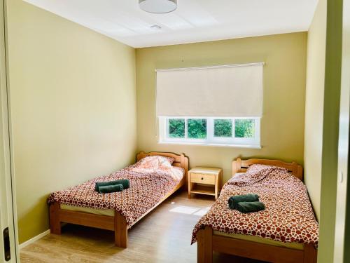 2 Betten in einem kleinen Zimmer mit Fenster in der Unterkunft Kopli puhkemaja Saaremaal in Kasti
