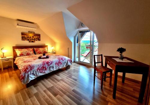 a bedroom with a bed and a desk and a table at GARTNAR HOME -Hiška s pridihom domačnosti in pogledom na hribe. in Radovljica