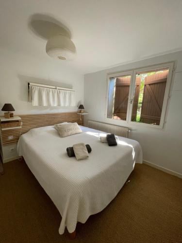 une chambre avec un grand lit blanc avec deux serviettes dessus dans l'établissement Large private garden, quiet 2-bedroom apartment, air conditioning, wifi, parking, à Cassis