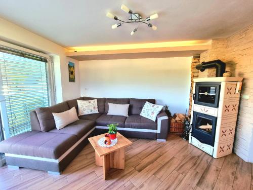 a living room with a couch and a stove at GARTNAR HOME -Hiška s pridihom domačnosti in pogledom na hribe. in Radovljica