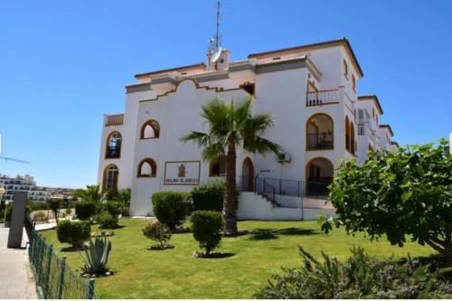 duży biały budynek z palmą przed nim w obiekcie Molino Blanco Penthouse 15 w mieście Playas de Orihuela