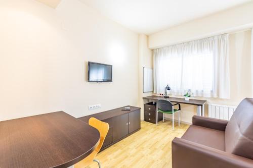 ein Wohnzimmer mit einem Tisch und einem Sofa in der Unterkunft Residencia Universitaria Erasmo in Madrid