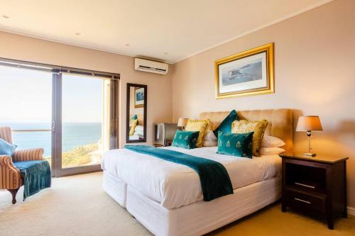 a bedroom with a bed with a view of the ocean at Aqua Terra Boutique Guesthouse in Simonʼs Town