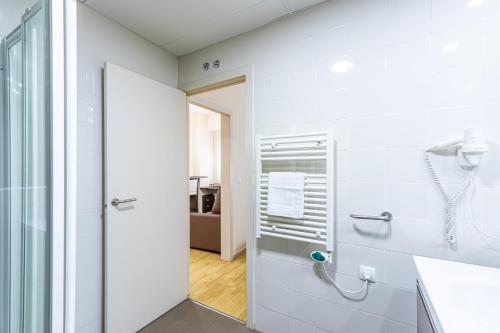 a white bathroom with a shower and a glass door at Residencia Universitaria Resa Erasmo in Madrid