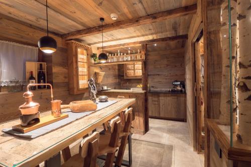 a kitchen with wooden walls and a counter with chairs at Residence Corn Le Tama in San Vigilio Di Marebbe