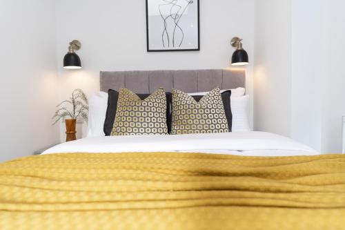 a bedroom with a bed with a yellow blanket at The Madison - Premium Self Check-In Studios & Apartments in Southampton