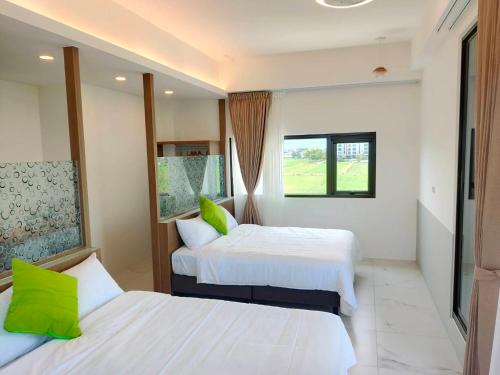 a hotel room with two beds and a window at FUN Style Homestay in Zhuangwei