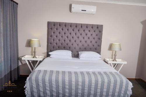 a bedroom with a large bed with two night stands at Avoca Vale Country Hotel in Louis Trichardt