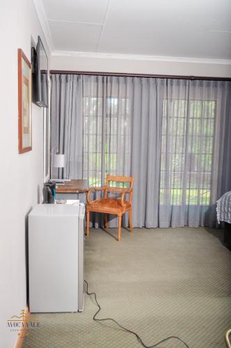a living room with a table and a chair at Avoca Vale Country Hotel in Louis Trichardt
