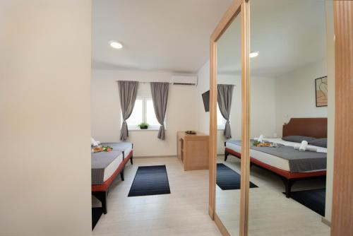 a bedroom with two beds and a mirror at Hotel Potpican in Potpićan