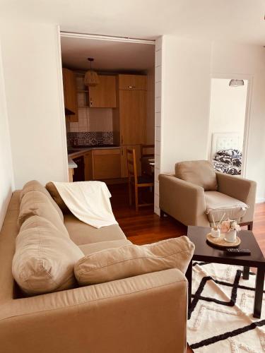 un salon avec un canapé et une table dans l'établissement Appartement 2 chambres avec parking privé gratuit, à Dijon