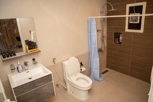 a bathroom with a toilet and a sink and a shower at 800 Mountain Resort Vacation House in Fujairah