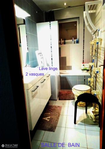 une cuisine avec des armoires blanches et une table à l'intérieur dans l'établissement LA BOUVIERE, à Aulnat