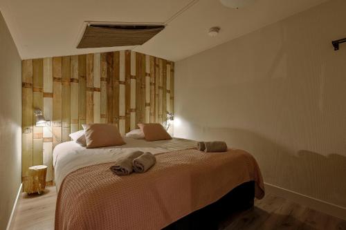 a bedroom with a large bed with towels on it at Doornvlak - dicht bij strand en duinen! in Castricum
