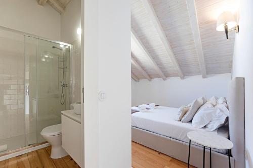 Habitación blanca con cama y ducha en D. João IV Apartments by LovelyStay, en Oporto