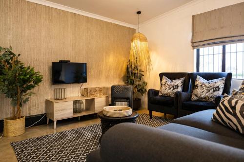 a living room with a couch and a tv at Fever Tree Guesthouse in Hillcrest