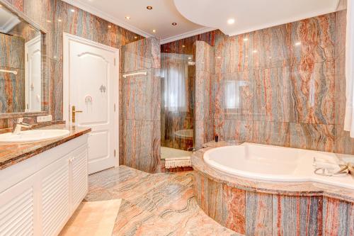 y baño con bañera y lavamanos. en Luxury villa El Duque Ocean View en Adeje