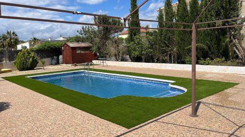 una piscina con césped a su alrededor en La Casa Arboleas, en Arboleas