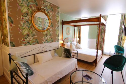 a bedroom with two beds and a mirror at Hotel de la Bretonnerie in Paris
