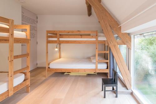 Cette chambre comprend 3 lits superposés et une chaise. dans l'établissement Het Wagenhuis, à Lo-Reninge