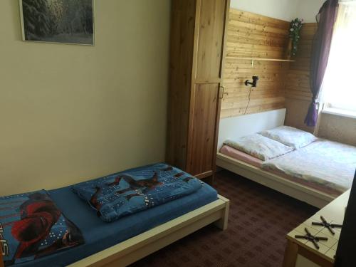 1 dormitorio con 2 camas en una habitación con ventana en Horský apartmán Krkonoše, en Vítkovice