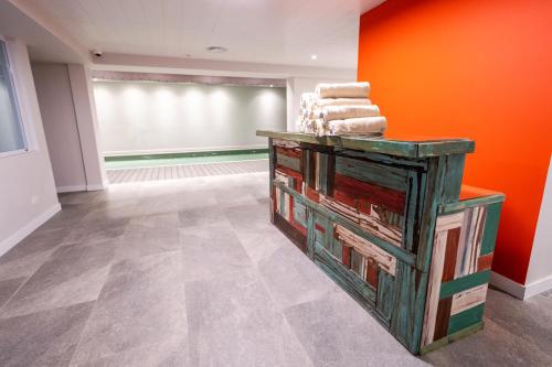 a room with orange walls and a table with towels at Cilene del Fuego Suites & Spa in Ushuaia