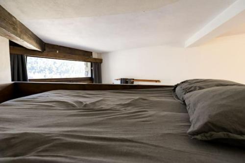 a large bed in a bedroom with a window at Les GRANDS SORBIERS à Méribel - Charmant studio situé à 2 pas des pistes & du centre de Méribel in Les Allues