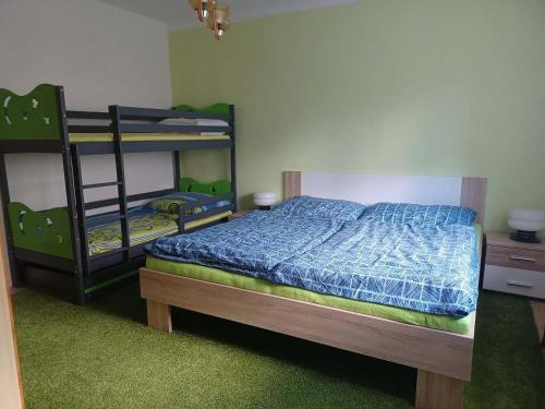 1 dormitorio con 2 literas y edredón azul en Apartmány u vleku, en Karlova Studánka
